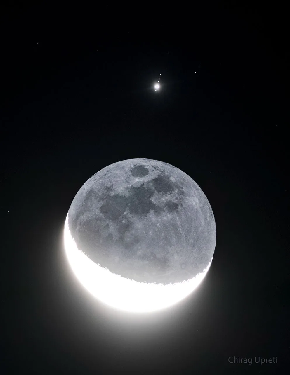 Fotografia aérea de Júpiter, suas quatro maiores luas e a Lua da Terra alinhadas no céu.