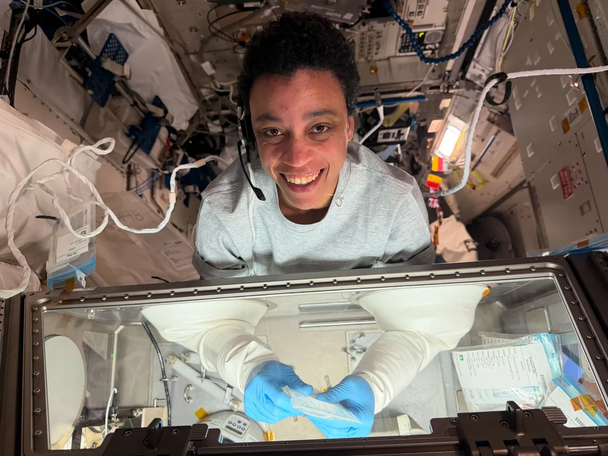 Astronauta Jessica Watkins trabalhando na estação espacial com equipamento de bioprinting