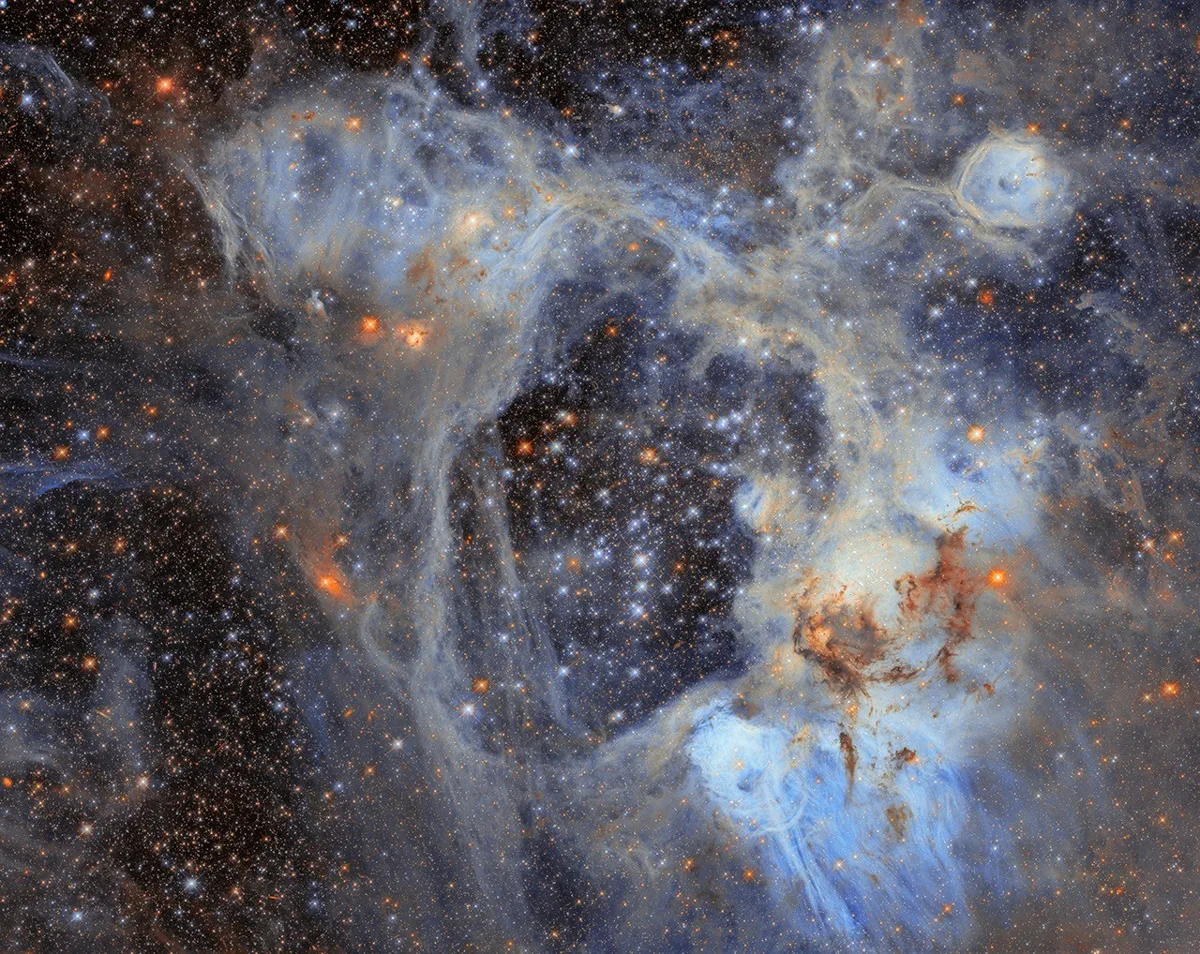 Imagem do telescópio Hubble mostrando a nebulosa N44 na Nuvem de Magalhães, com destaque ao superbubble central e estrelas em formação.
