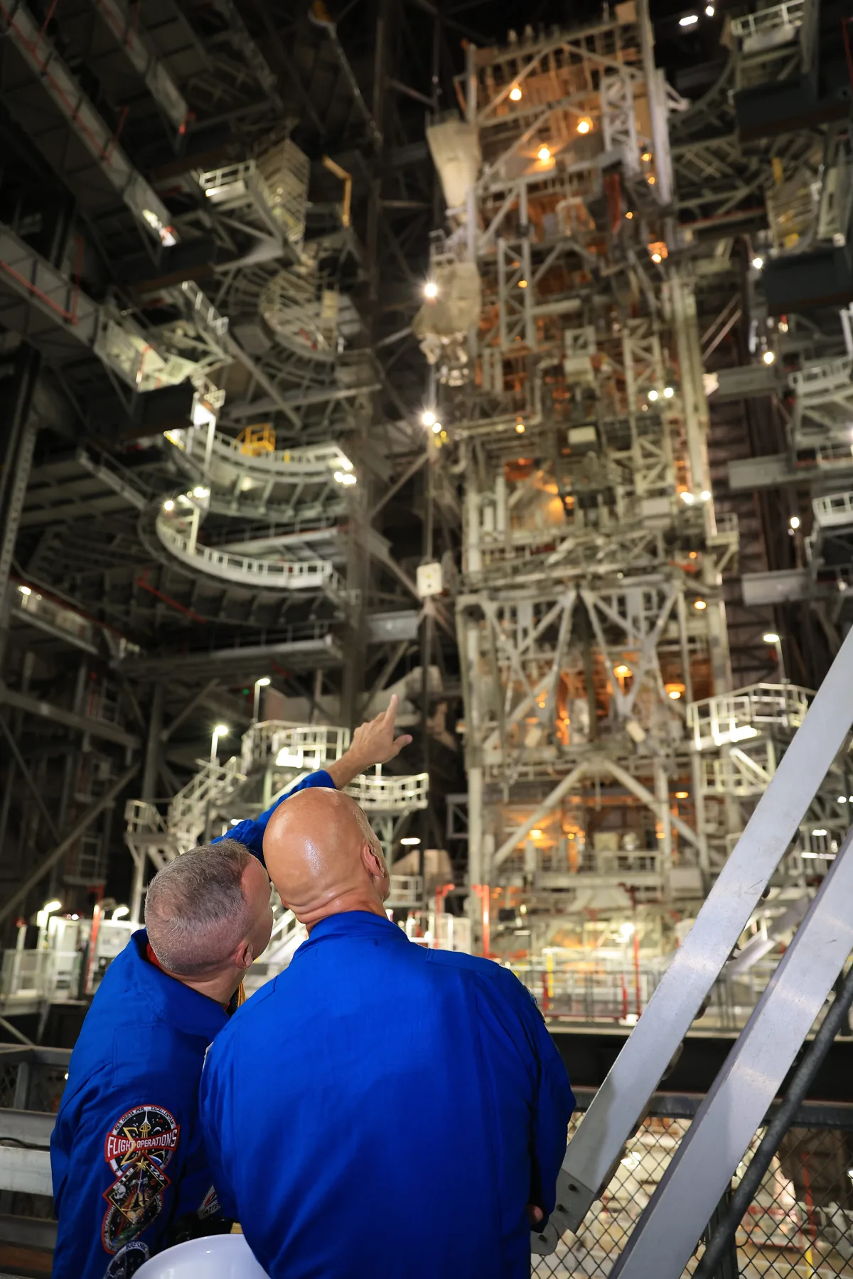 Astronautas observando a montagem do foguete no Kennedy Space Center.