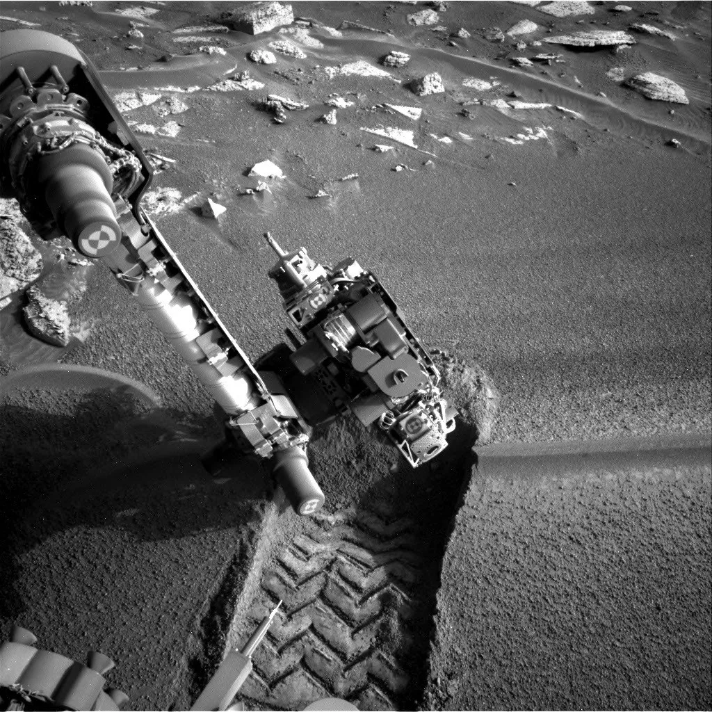 Imagem do rover Curiosity analisando uma formação rochosa em Marte